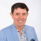 Headshot of a man with dark hair who dressed in a light blue suit.