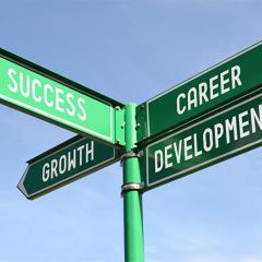 A green street sign with growth, success and career development arrows pointing in different directions.